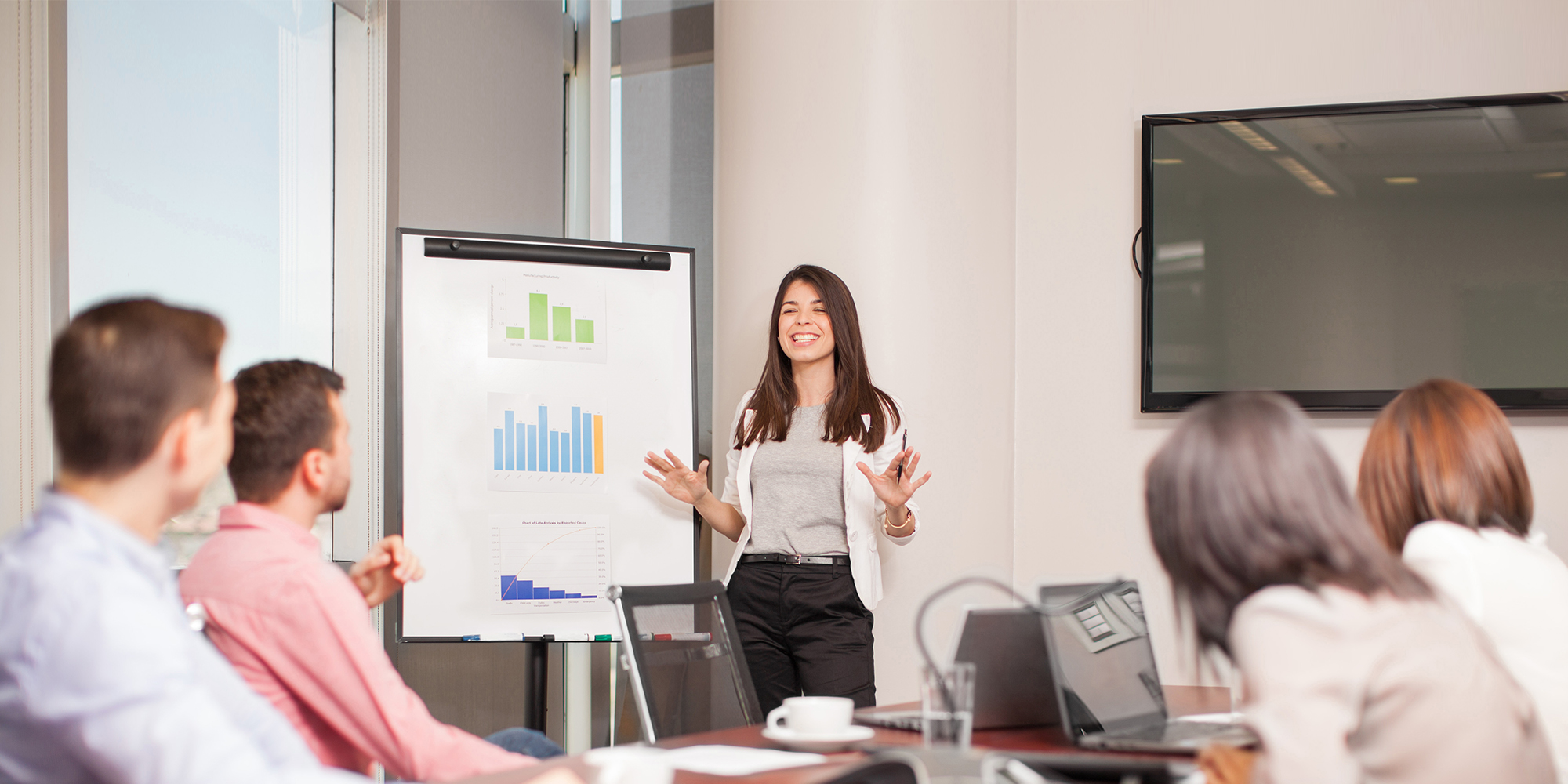 Woman gives pitch presentation to board room 