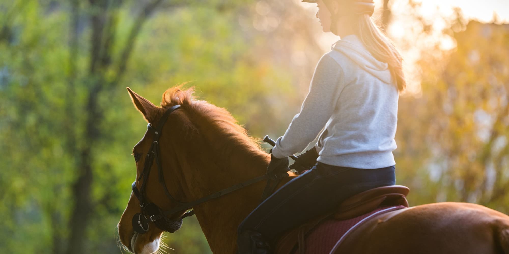 Young white woman rides a brown horse. 